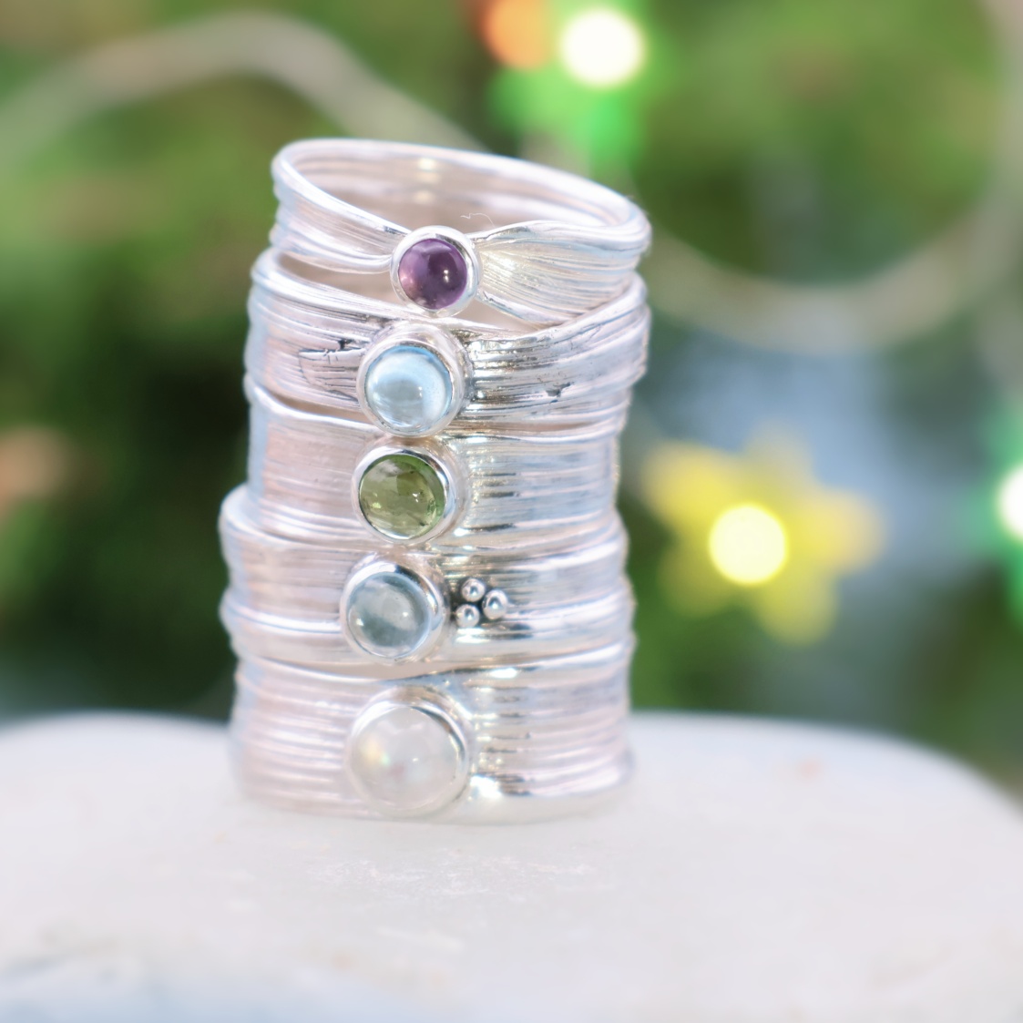 stack of narrow wave rings in silver with gems